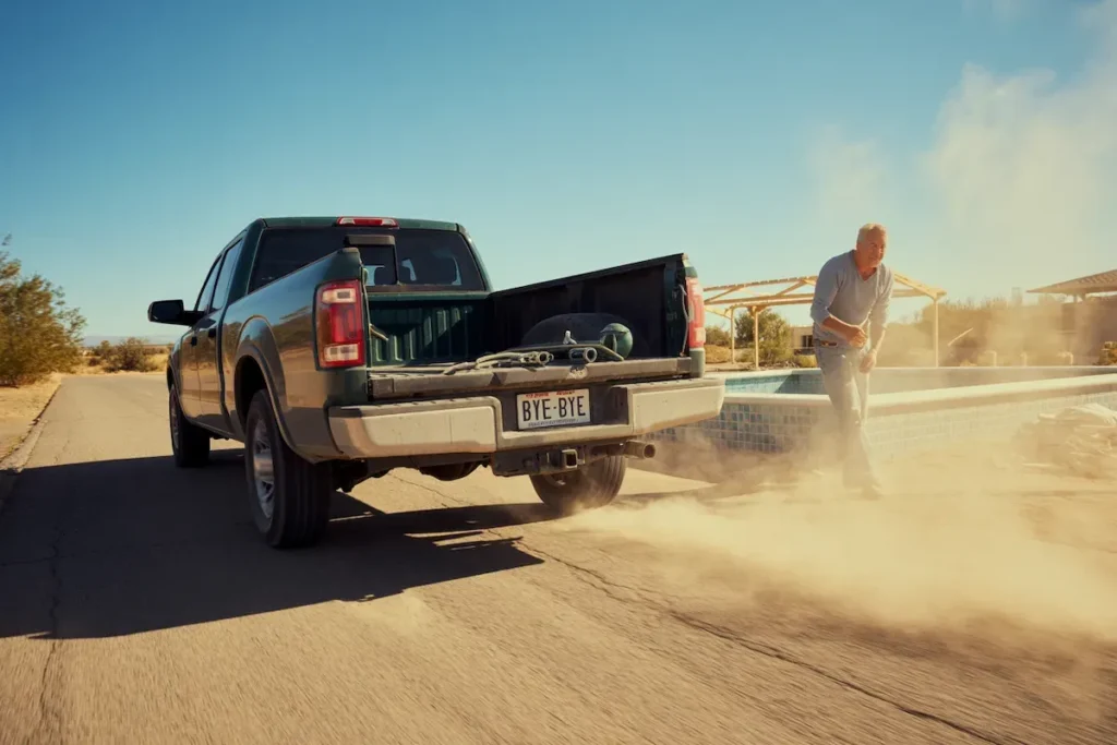 Pickup Truck With Open Bed Kicking Up Dust At Pool Construction Site